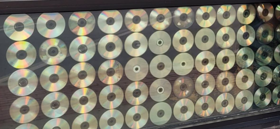 Rows of compact discs mounted in the front window, catching the light.