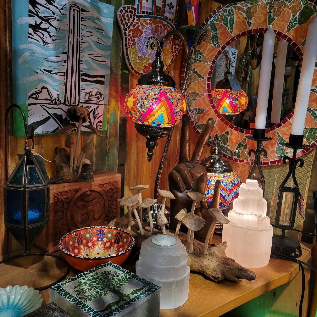 Mosaic lamps, glowing selenite towers, carved mushrooms and an Om box on a shelf.