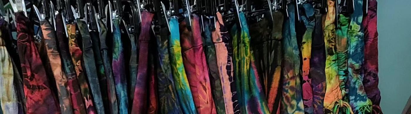 A rack of tie dye dresses in every color.